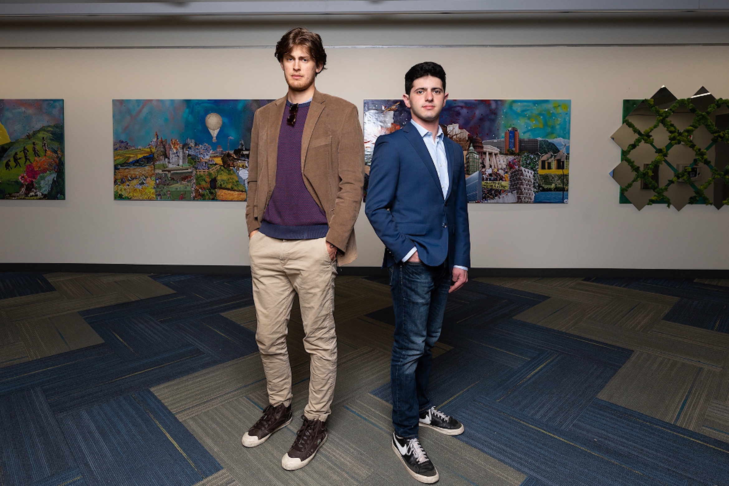 ELI students Noah Weiss and Lukas Kraak stand in front of their art exhibit at the UCSB library